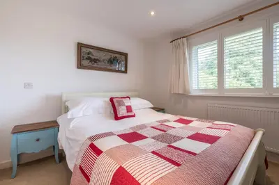 a bedroom with a bed with a red and white quilt at Trestar in Wadebridge