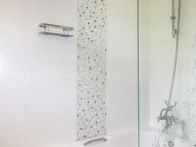 a shower with a glass door next to a tub at Trestar in Wadebridge