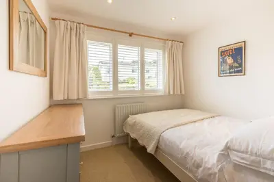 a bedroom with a bed and a desk and a window at Trestar in Wadebridge
