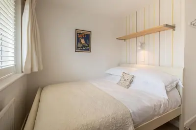 a bedroom with a white bed with a picture on the wall at Trestar in Wadebridge