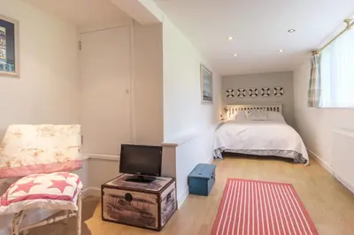 a bedroom with a bed and a tv and a chair at Trestar in Wadebridge