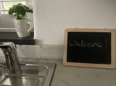 a chalkboard sign on a kitchen counter with a plant at Little Barn in Bodmin