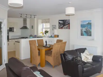 a kitchen and living room with a table and chairs at Ocean Breezes in St Ives