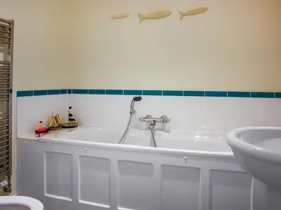 a bathroom with a bath tub and a sink at Ocean Breezes in St Ives