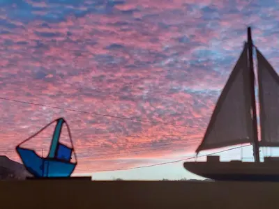 a sailboat and a boat under a cloudy sky at Ocean Breezes in St Ives