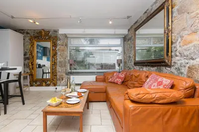 a living room with a leather couch and a table at The Old Salthouse in St Ives