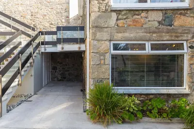 a brick building with a window and a staircase at The Old Salthouse in St Ives