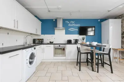 a kitchen with a washing machine and a table at The Old Salthouse in St Ives