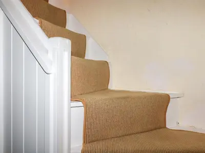 a set of stairs with a brown chair next to it at Willow View in Wadebridge