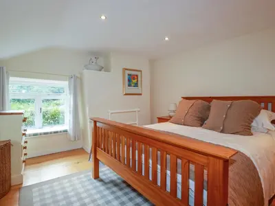 a bedroom with a large bed and a window at Willow View in Wadebridge