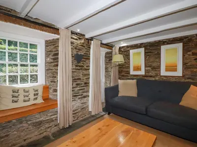 a living room with a couch and a window at Willow View in Wadebridge