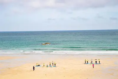 a group of people standing on the beach at The St Ives Bay Hotel in St Ives