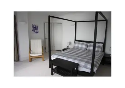 a bedroom with a canopy bed and a chair at Ocean View, 5 bedrooms sleeps 10, stunning views, parking x4 in Mevagissey