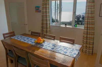 a dining room table with a bowl of fruit on it at Ocean View, 5 bedrooms sleeps 10, stunning views, parking x4 in Mevagissey