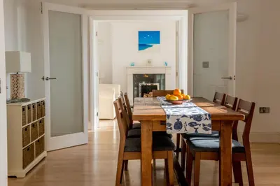 a kitchen and dining room with a wooden table and chairs at Ocean View, 5 bedrooms sleeps 10, stunning views, parking x4 in Mevagissey