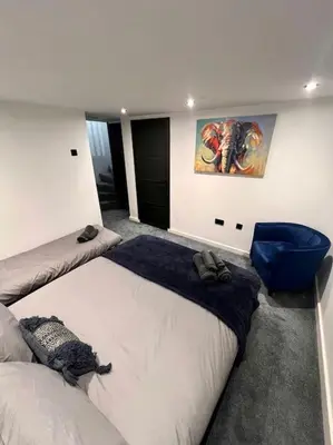 a bedroom with two beds and a painting on the wall at The Middleton Beach Lodge in Looe