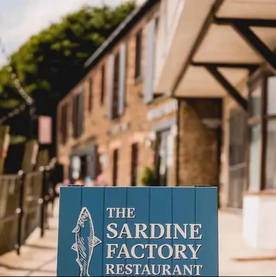 a sign that reads the sardine factory restaurant at The Middleton Beach Lodge in Looe