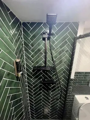 a bathroom with a green and black tiled wall at The Middleton Beach Lodge in Looe