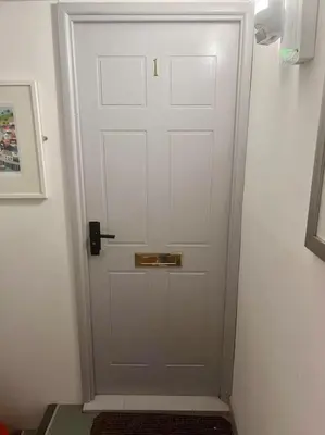 a white door with a gold handle in a hallway at The Middleton Beach Lodge in Looe