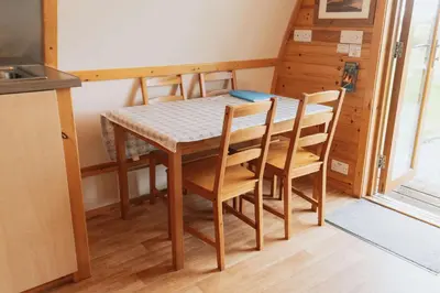 a dining room table and chairs in a kitchen at Great Tregath by Wigwam Holidays in Camelford