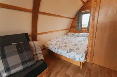 a small bedroom with a bed and a window at Great Tregath by Wigwam Holidays in Camelford