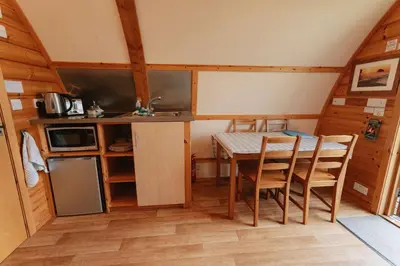 a kitchen and dining room with a table in a cabin at Great Tregath by Wigwam Holidays in Camelford