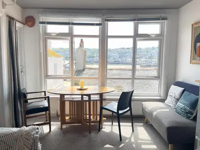 a living room with a table and a couch at 1 Sunnyside - views over the St Ives Harbour in St Ives