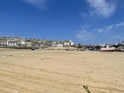 a sandy beach with buildings in the background at 1 Sunnyside - views over the St Ives Harbour in St Ives