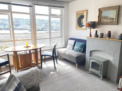 a living room with a table and a fireplace at 1 Sunnyside - views over the St Ives Harbour in St Ives