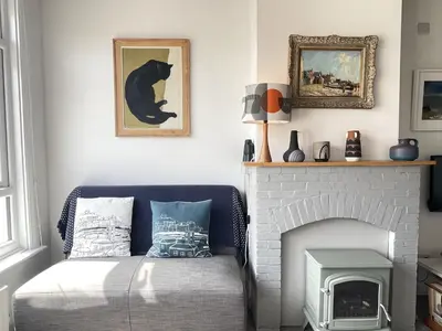 a living room with a bed and a fireplace at 1 Sunnyside - views over the St Ives Harbour in St Ives
