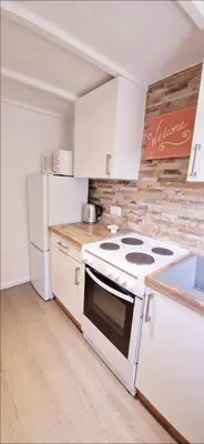 a kitchen with a stove and a refrigerator at Cottage in Newquay