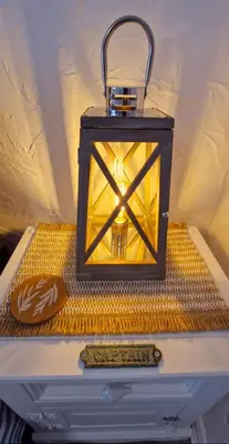 a lantern on top of a dresser with a remote control at Cottage in Newquay