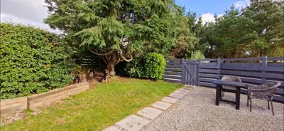 a bench and a table next to a fence at Cottage in Newquay