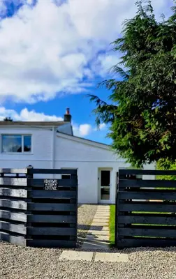 a white house with a gate in front of it at Cottage in Newquay