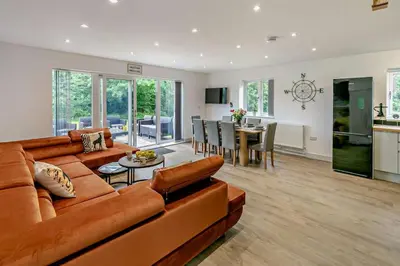 a living room with a brown couch and a dining room at 4 Bed in Retorrick Mill oc-t28899 in Saint Mawgan
