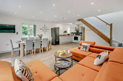 a living room with an orange couch and a table at 4 Bed in Retorrick Mill oc-t28899 in Saint Mawgan