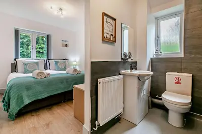 a bedroom with a bed and a toilet and a sink at 4 Bed in Retorrick Mill oc-w28897 in Saint Mawgan