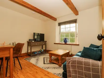 a living room with a couch and a table at Lower Gadles in Penryn