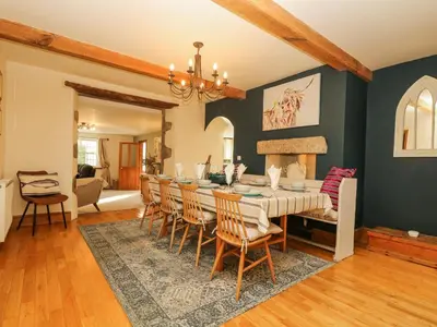 a dining room with a long table and chairs at Lower Gadles in Penryn