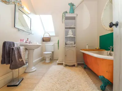 a bathroom with a bath tub and a sink at Lower Gadles in Penryn