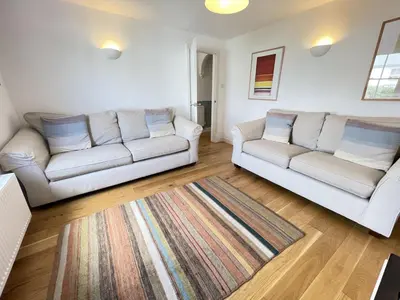 a living room with two white couches and a rug at 2 Meadow Villas in St Ives
