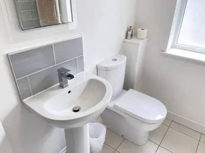a white bathroom with a sink and a toilet at 2 Meadow Villas in St Ives