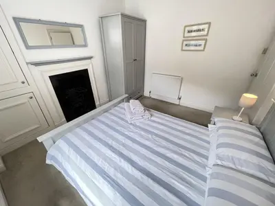 a bedroom with a bed and a fireplace at 2 Meadow Villas in St Ives