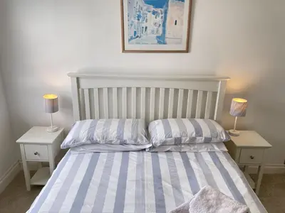 a bedroom with a bed with two lamps on tables at 2 Meadow Villas in St Ives