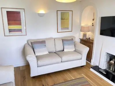 a living room with a white couch and a tv at 2 Meadow Villas in St Ives