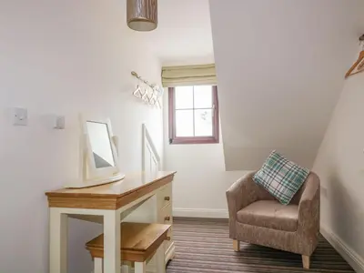 a room with a desk and a chair and a mirror at The Beach Hut in Newquay