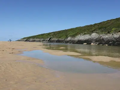 a sandy beach with a body of water at The Beach Hut in Newquay