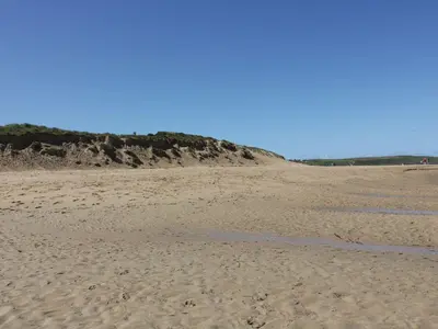 a sandy beach with a bluff in the distance at The Beach Hut in Newquay