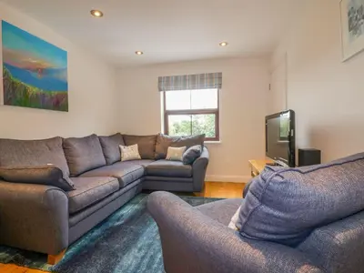 a living room with a couch and a tv at The Beach Hut in Newquay