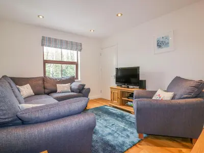a living room with two couches and a flat screen tv at The Beach Hut in Newquay